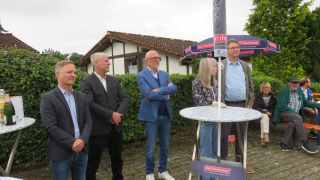 Einige aufmerksame Zuhörer an einem Stehtisch