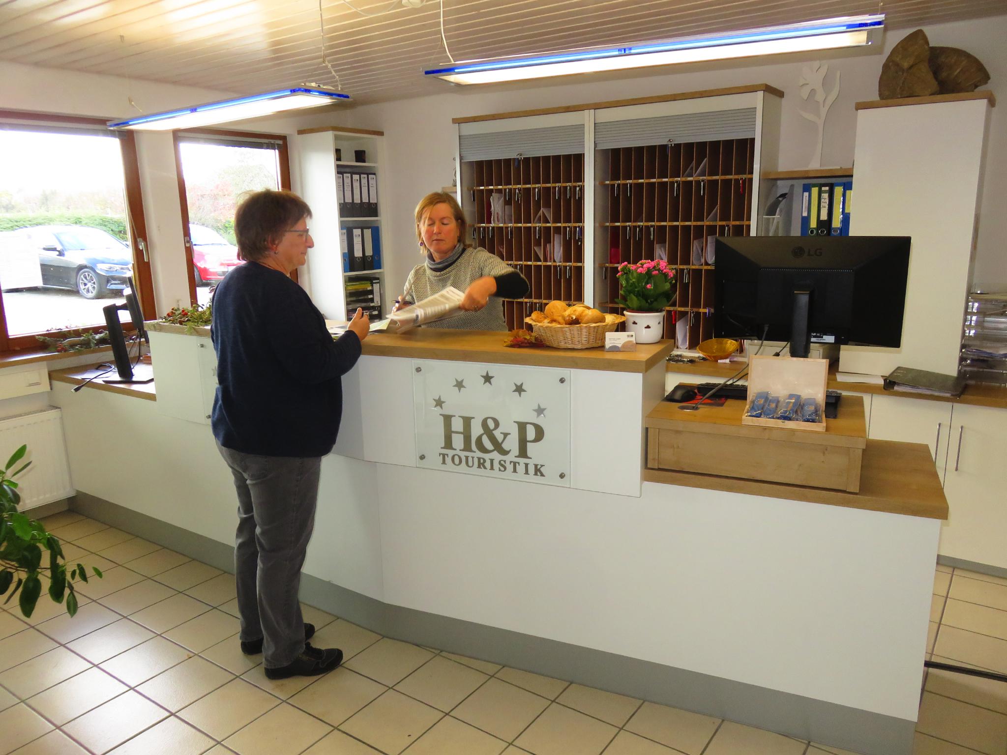 Bild der Rezeption mit Gast und Mitarbeiterin