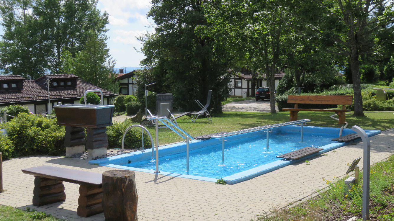 Ansicht des Kneippbeckens mit Sitzbank, Armbecken zwischn dem Bewuchs im Feriendorf