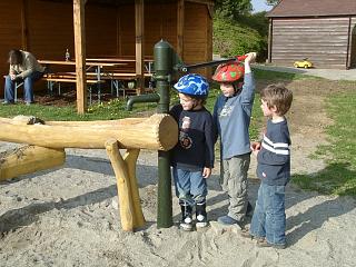 Kinder an der Wasserpumpe auf dem Spielpatz
